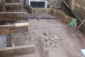 The area to the side of the house was dug down to bedrock and levelled, taking care to allow for window spaces and a planing area.